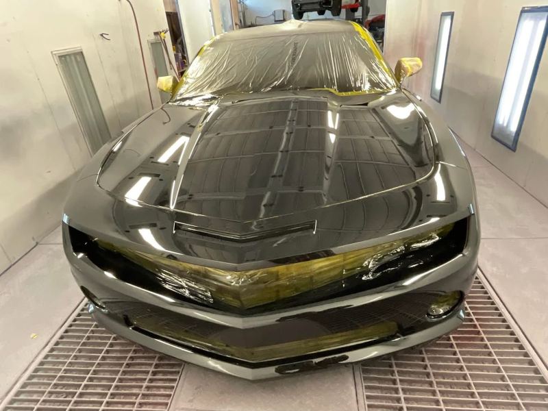 Front view of the Camaro's freshly painted bonnet and bumper in the spray booth