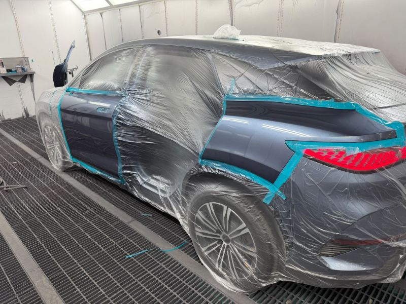 Grey BYD SUV masked in the spray booth with the door and neighbouring panels prepared